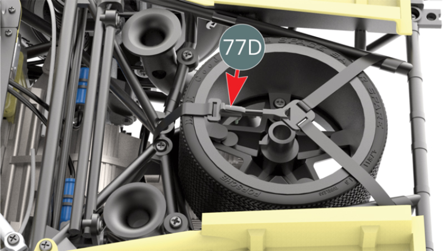 The spare wheel is secured with the spare wheel strap (77D) on top.