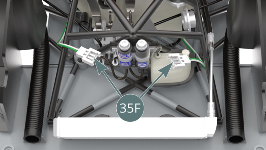 At the front end of the chassis, place the connectors for the headlight LED cables (35F) into the position indicated opposite.