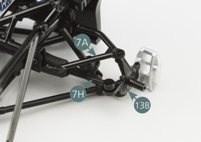Position the left front pivot (13B) on the lower left suspension arm (5C), on the steering tie-rod (7H) and on the upper left suspension arm (7A), then secure it to the latter with a DM screw. Turn the suspension assembly over and secure the left front pivot (13B) to the lower left suspension arm (5C) and steering tie-rod (7H) using two DM screws.