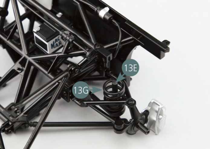 Position the suspension spring (13G) and suspension shock absorber (13F) on the suspension piston pin (13E). Place the head of the suspension shock absorber (13F) onto the chassis top frame (11A) and secure it with a GM screw.