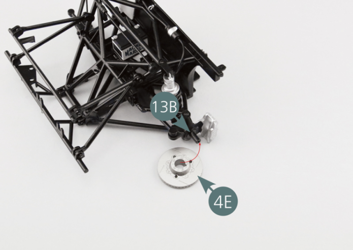 Position the brake disc (4E) on the front left wheel pivot (13B). The cone in the center of the disc should face outwards. Pay attention to the small notch (red circle). 