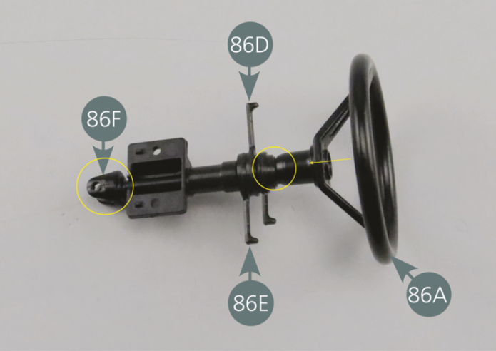 Positionner le volant 86A sur la colonne de direction 86 F, puis le fixer avec une vis SM à l’extrémité et au centre de la colonne.Détacher l’écusson autocollant 86B de son support papier et le positionner au centre du volant, en veillant au bon positionnement du dessin de scorpion du logo.Veiller également à ce que le nom ABARTH soit bien positionné sur la branche droite, comme indiqué sur la photo.
