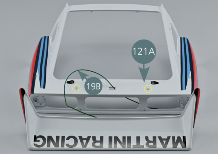 Bend the LED connections using pliers and insert the H1-1 cable lightning license plate (19B) into the housing provided beneath the rear spoiler (123A). Secure the cable with adhesive tape (123C) as shown.