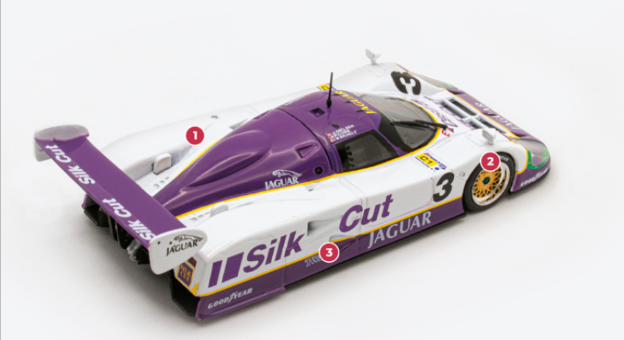 1. The V12 engine was derived from the block used in series production Jaguars, with the bore and stroke increased to 7 litres.2. The XJR12's dimensions were largely unchanged from those of the XJR9. The front track was increased from 1,500 mm to 1,550 mm.  3. The existing large slots on the sides of the XJR9 were replaced by two NACA air intakes.© IXO Collections SAS - Tous droits réservés. 