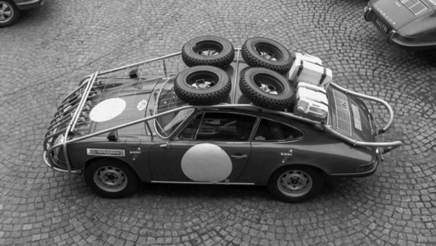 Vista superior de um dos carros 911 S no início do Rali Londres-Sidney: a estrutura reforçada serviu também de bagageira para pendurar rodas sobresselentes e latas de óleo e gasolina.© IXO Collections SAS - Tous droits réservés.&nbsp;