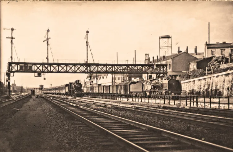 Nordvorstadt-Atmosphäre in den 1950er Jahren unter einer typischen Signalbrücke des ehemaligen Nordnetzes. Auf der rechten Seite wird ein Ex-PLM-„Pacific“ vor einen schweren und langsamen Güterzug des „Régime Ordinaire“ gespannt, eine Rolle, die eher einem 141-R zufallen würde. Links ein Vorortzug, der von einer alternden 230 Nord gezogen wird.© IXO Collections SAS - Tous droits réservés. Crédits photo © Collection Trainsconsultant-Lamming