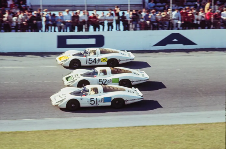 La parata trionfale delle Porsche 907LH che hanno appena conquistato i tre gradini del podio alla 24 Ore di Daytona del 1968. La vincente è la n. 54, condotta a turno da ben cinque piloti.© IXO Collections SAS - Tous droits réservés.&nbsp;