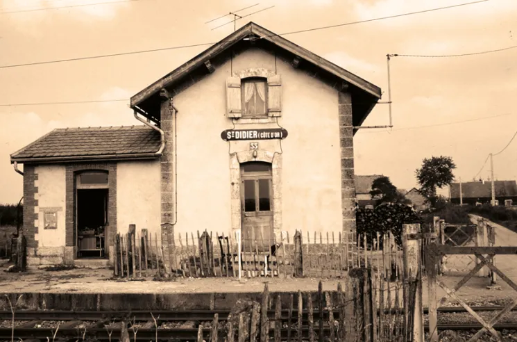 La petite gare de St-Didier, Côte d’or, ligne de Dracy-St-Loup à Maison-Dieu, est typique de ces points d’arrêt dont la garde-barrière assure un modeste service voyageurs et messageries. Nous sommes dans les années 1970. Le réseau ferré français rural se meurt dans l’indifférence, malgré les efforts des 141-R.© IXO Collections SAS - Tous droits réservés. Crédits photo ©&nbsp;Document Alain Pras.
