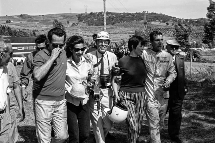 Umberto Maglioli, a la izquierda, con su esposa Mary durante su victoria en la Targa Florio de 1958. A la derecha, el director técnico del equipo Porsche, el expiloto Fritz Huschke von Hanstein.© IXO Collections SAS - Tous droits réservés. 
