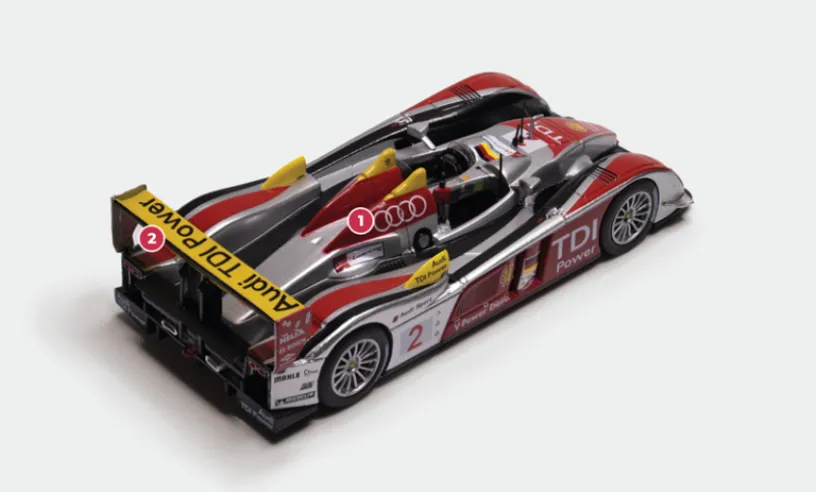 1. The V12 twin-turbo engine of the TDI, built entirely of aluminium like the previous V8 petrol engines, delivers nearly 650 hp.2. Cars No. 2 and No. 1 were entered at Le Mans in 2008 by the Audi North America team, while No. 3 raced under the colours of Team Audi Joest. Despite this split, the cars were given identical liveries, with the exception of the spoiler and the tips of the two rear wings, which were yellow on car no. 2, red on car no. 1 and black on car no. 3. © IXO Collections SAS - Tous droits réservés. 
