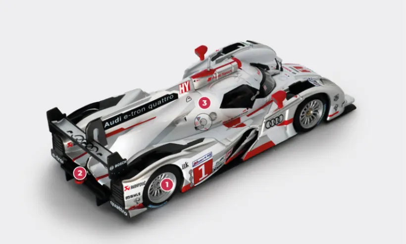 1. All wheels feature double-wishbone suspension, but the front springs are operated by a push-rod system with reaction arms, while the rear springs are operated by pull-rods.2. To save weight and compensate for the added mass of the hybrid system, the 2012 R18 e-tron quattro is equipped with a gearbox whose housing is made of carbon fibre.3. Compared to the previous V10 5.5 used in the R15, the V6 3.7 engine in the R18 is powered by a single variable turbine geometry installed between the cylinder banks, opened at 120°.© IXO Collections SAS - Tous droits réservés.