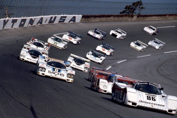 Mise en grille des voitures au départ des 24 Heures de Daytona 1986. Au premier plan, la Porsche 962 n° 86 de l’équipe Bayside avec Bob Wollek qui part en deuxième position avant d’abandonner sur accident.© IXO Collections SAS - Tous droits réservés. 