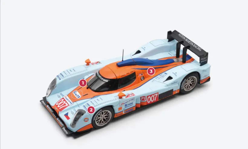 1. Die Form ist fließender und weniger eckig als die der Lola B08/60-Modelle, denen der B09/60 „signed” DBR1-2 von Aston Martin als Grundlage dient.2. Die Karosserie aus Kohlefaser und die Vorderradaufhängung des ursprünglichen Fahrwerks der Lola wurden von Aston Martin unverändert übernommen, wobei hauptsächlich am Heck Modifikationen durchgeführt wurden.3. Die periskopischen Lufteinlässe zur Belüftung der Hinterradbremsen wurden entfernt. Die Bremsscheiben werden durch einen hinteren Kühlergrill mit Elektrolüfter gekühlt.© IXO Collections SAS - Tous droits réservés.&nbsp;