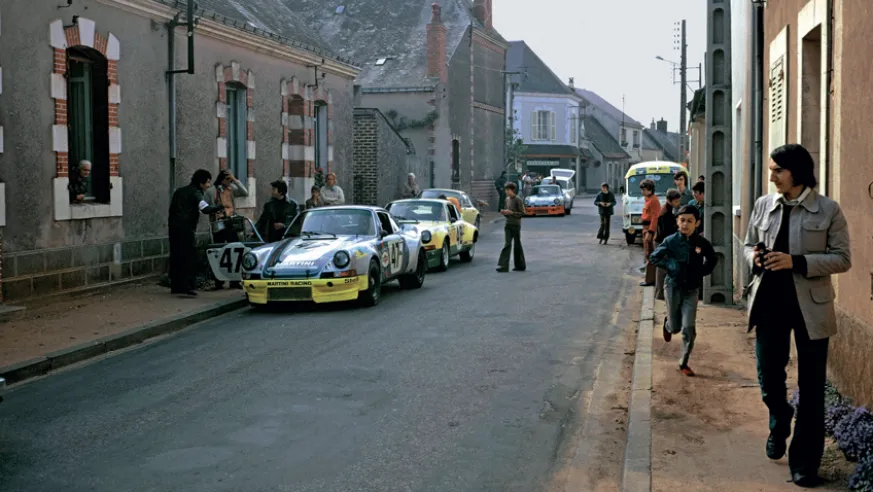 On the streets of Le Mans, some 911 Carrera RSRs on their way to the start of the 1973 24 Hours. In the foreground, is the official car being driven by Reinhold Joest and Claude Haldi, who would later retire from the race.© IXO Collections SAS - Tous droits réservés.