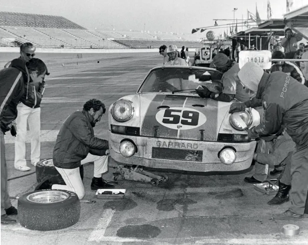 The Brumos team's 911 Carrera RSR with its mechanics before victory in the 1973 Daytona 24 Hours.© IXO Collections SAS - Tous droits réservés.