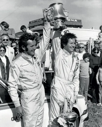 Hurley Haywood (left) and Peter Gregg (right) lifting the trophy won at the 1973 Daytona 24 Hours. This was their first victory in this event.© IXO Collections SAS - Tous droits réservés.
