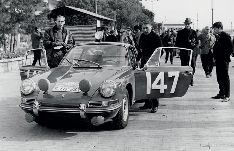 Herbert Linge avec la Porsche 911 qui, en janvier 1965, marque le début en compétition de ce modèle dans le Rallye de Monte-Carlo. Le moteur type 901 installé sur la 904/6 provient de cette série.© IXO Collections SAS - Tous droits réservés. 